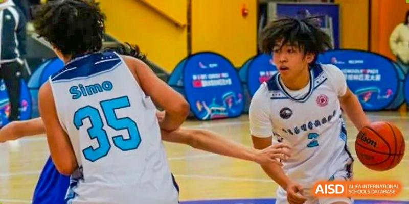 A close-up action shot of students playing basketball during an indoor sports activity at Weiming International Qingdao.