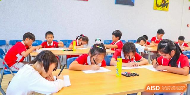Young students from Sanya Haiya  Foreign Language School working on a class assignment at their desks.