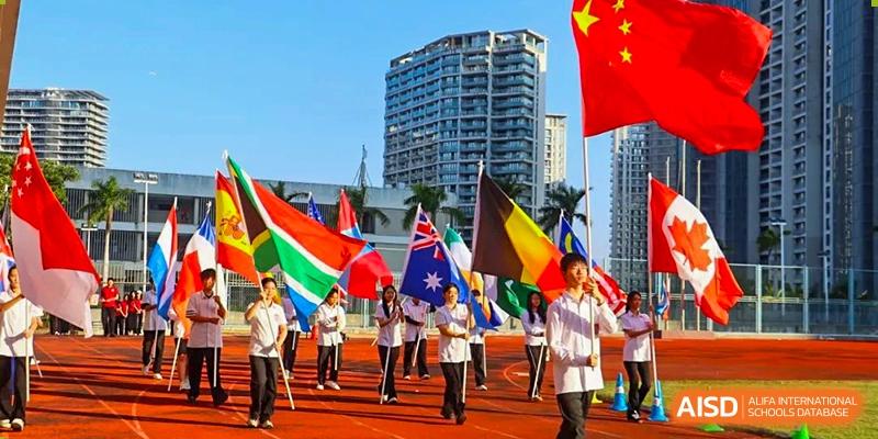 Sanya Haiya Foreign Language School students with flags of different countries at a sports event.