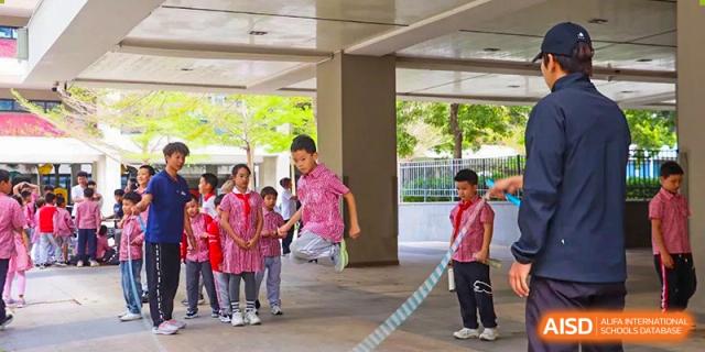 Students from Sanya Haiya   Foreign Language School playing jump rope outside.