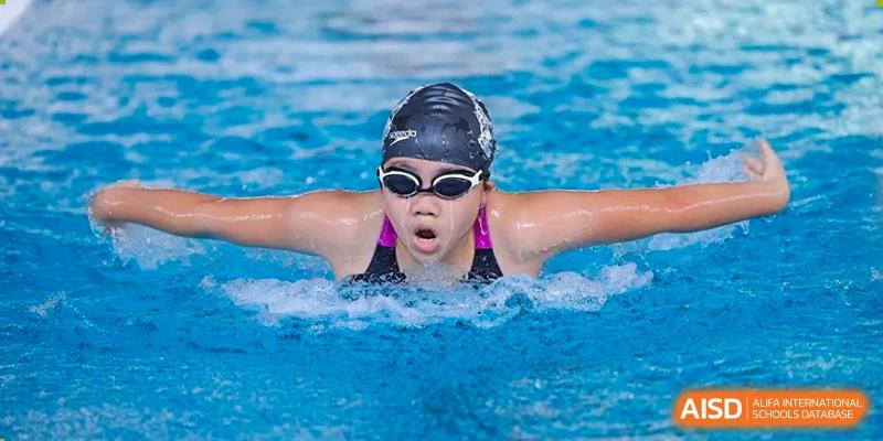 A close-up of a Sanya Haiya  Foreign Language School swimmer wearing goggles during a race.