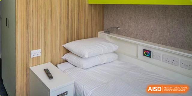 A clean bed with pillows in a dormitory at Sanya Haiya  Foreign Language School.