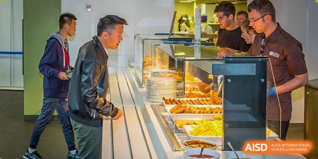 A student from Sanya Haiya  Foreign Language School choosing food from a cafeteria food line.