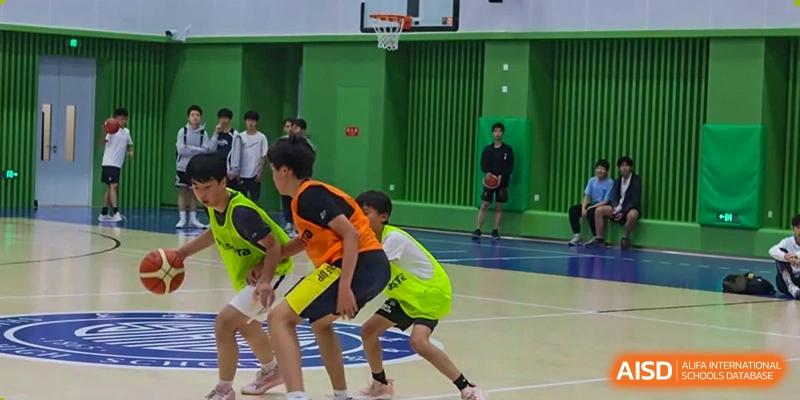 Students playing basketball on an indoor court at Shanghai High School International Division.