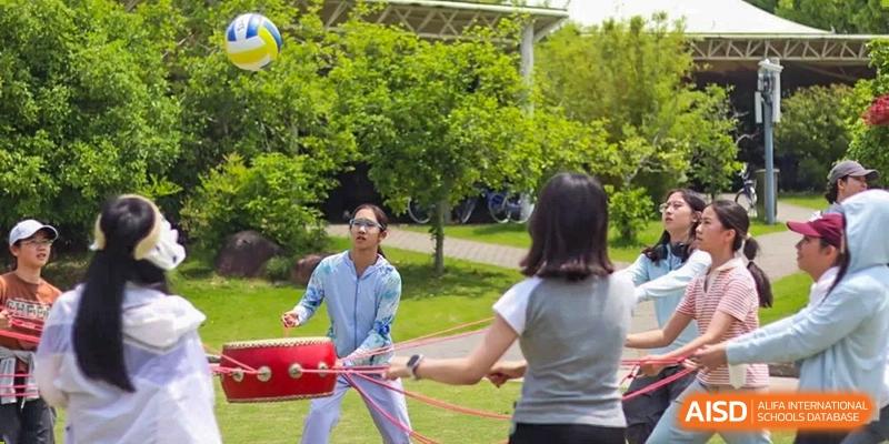 A student participating in a team-building or outdoor game involving a rope at Shanghai High School International Division.