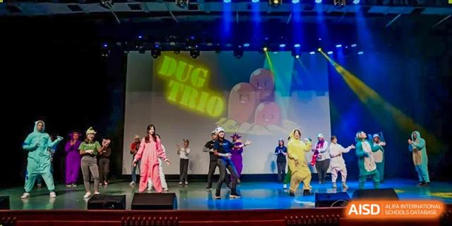 Students performing an energetic musical or dance routine on a stage at Shanghai High School International Division.