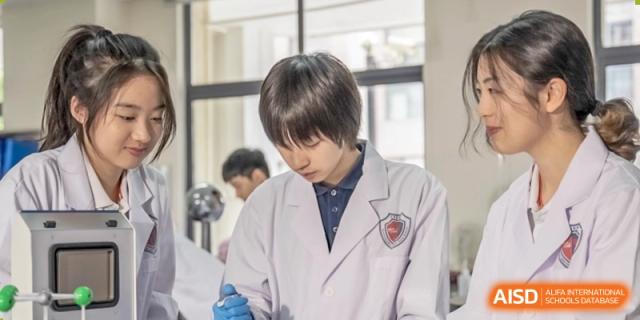 A Shanghai Qibao Dwight High School student in a lab coat looks down at an experiment.