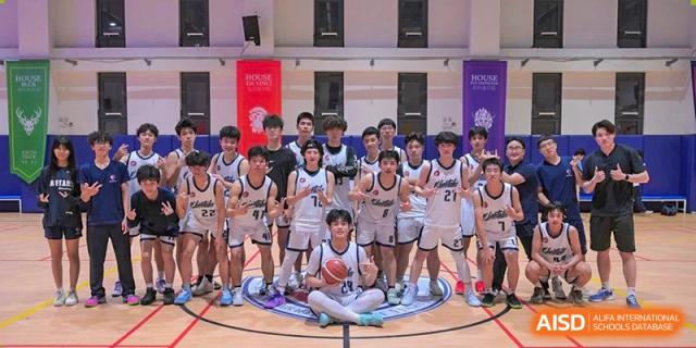 A group of basketball players from Shanghai Qibao Dwight High School pose for a team photo on the court.