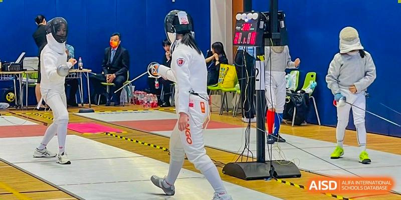 A student from Shanghai Qibao Dwight High School in full fencing gear with a foil in hand.