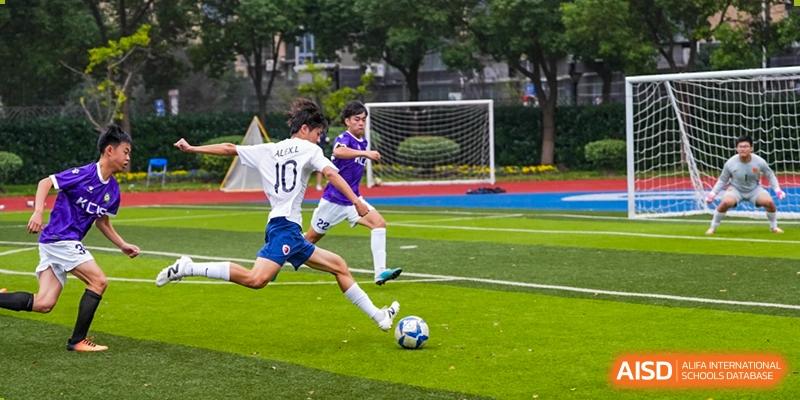 A student from Shanghai Qibao Dwight High School wearing jersey number 10 dribbles a soccer ball during a game.