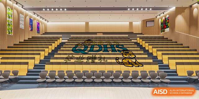 The interior of the Shanghai Qibao Dwight High School gym, showing the school's logo on the floor and rows of chairs.