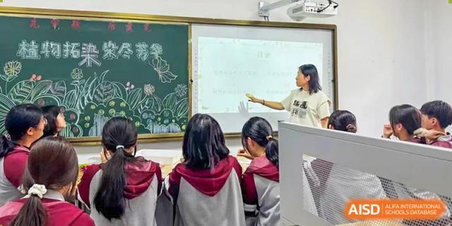 A teacher pointing to a screen during a lesson for students in a classroom at Shenyang Feiyue Experimental School.