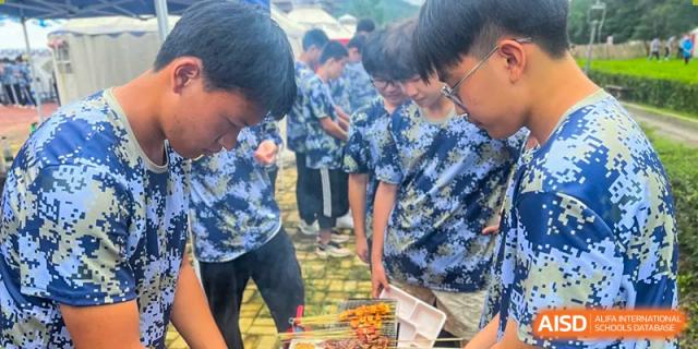 A close-up of students watching food being cooked on skewers at Shenyang Feiyue Experimental School.