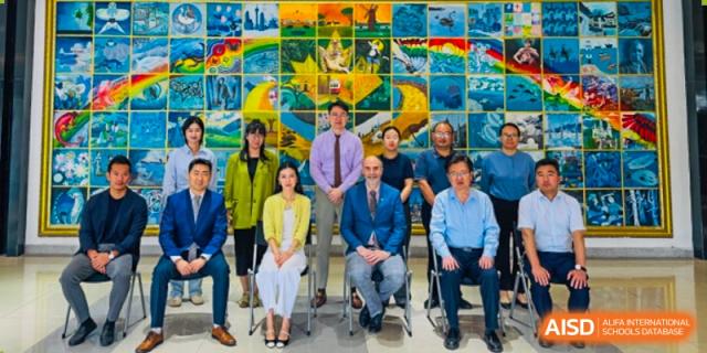 A group of teachers and staff from Sino-Canada School smiling and posing for a group photo.