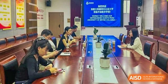 A group of faculty members or administrators from Sino-Canada School seated around a large conference table, engaged in a meeting.