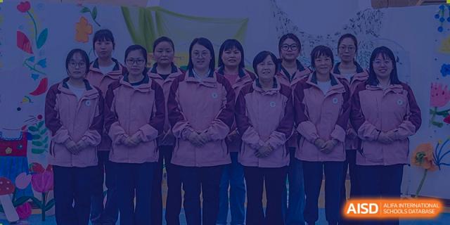 A group of female students from Sino-Canada School standing together and posing for a class photo.
