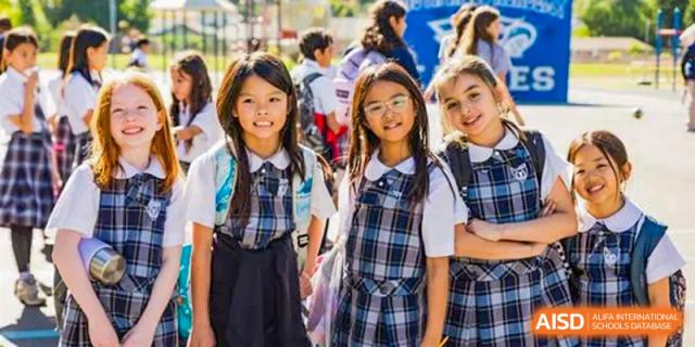 Two female students from Sino-Canada School wearing school uniforms and smiling for the camera.