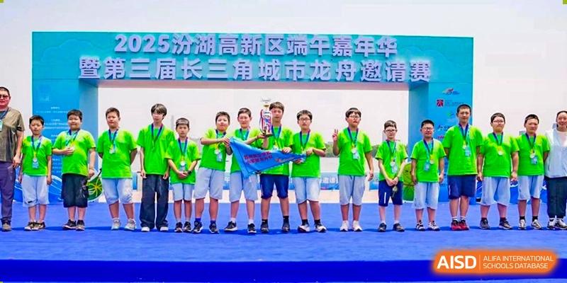 A group of students holding a banner and standing on a stage during an event at Sino-Canada School.