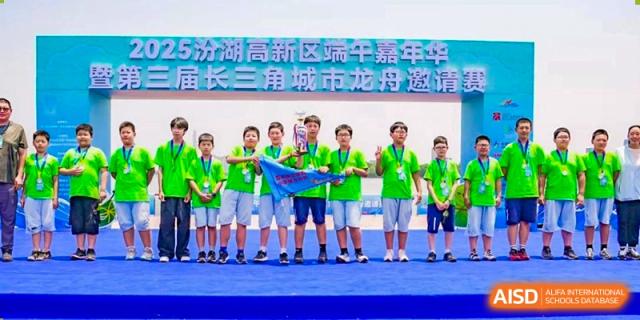 A group of students holding a banner and standing on a stage during an event at Sino-Canada School.