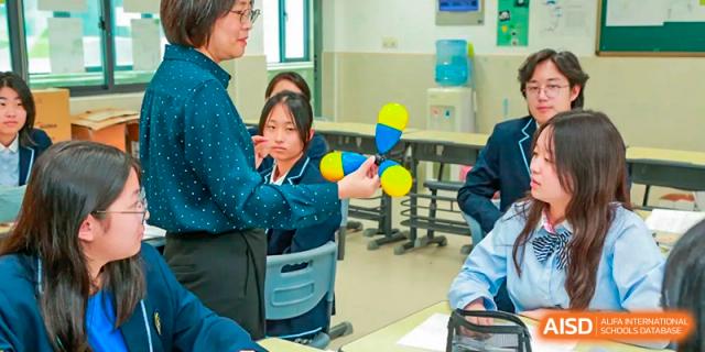 A female student from Suzhou Experimental High School International Center holds a molecular model during a science class.