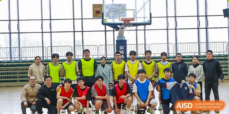A group of male students from Suzhou Experimental High School International Center, some wearing yellow vests, pose for a group photo on a basketball court.