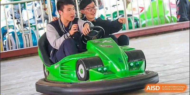 Two students from Suzhou Experimental High School International Center ride a green go-kart.