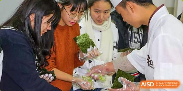 Two female students from Suzhou Experimental High School International Center prepare sushi rolls.