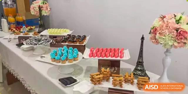 A table at Suzhou Experimental High School International Center is covered with a variety of colorful cupcakes and pastries.