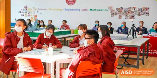 A group of students in red shirts are sitting in a classroom at The MacDuffie School Tianjin.