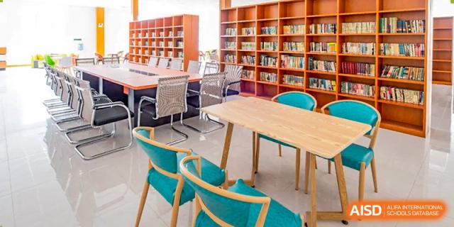 A study area with chairs and tables in a library at The MacDuffie School Tianjin.
