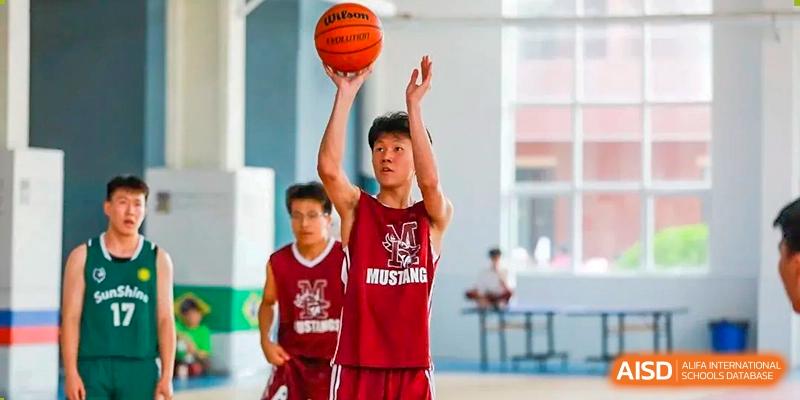 A male student from The MacDuffie School Tianjin shoots a basketball during a game.