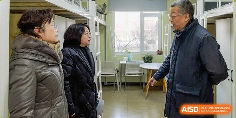 A teacher from The MacDuffie School Tianjin stands in a brightly lit room with a student.