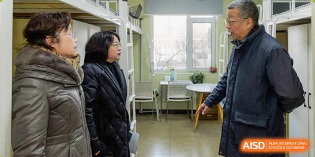 A teacher from The MacDuffie School Tianjin stands in a brightly lit room with a student.