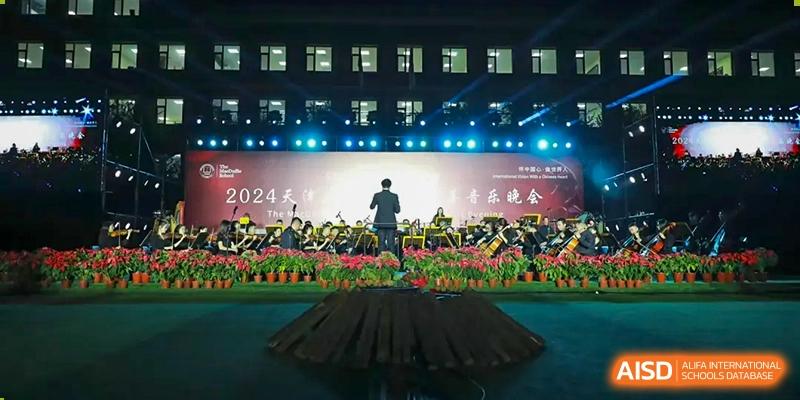 A student from The MacDuffie School Tianjin gives a speech on a stage during a graduation ceremony.