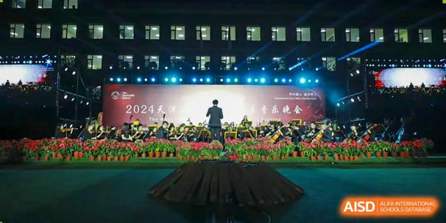 A student from The MacDuffie School Tianjin gives a speech on a stage during a graduation ceremony.