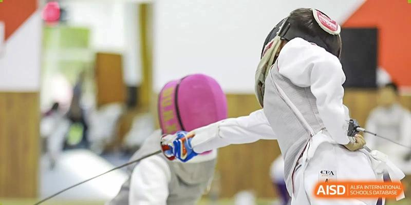 Two students from The MacDuffie School Tianjin are engaged in a fencing match.