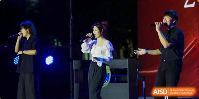A female student is singing on stage at a school event at The MacDuffie School Tianjin.