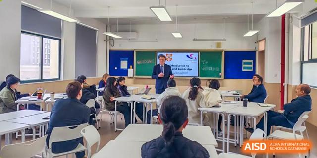 An academic class at Zhejiang Wenzhou High School International Division where a teacher stands by a whiteboard, lecturing to students seated at desks.