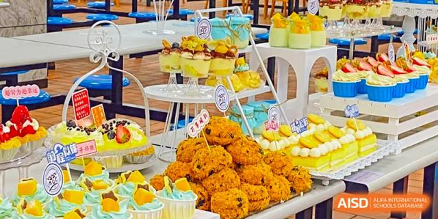 A colorful display of party food, including golden fried chicken and tiered desserts, for an event at Zhejiang Wenzhou High School International Division.