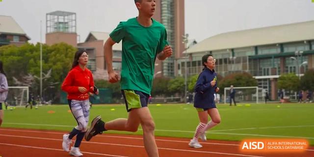 A male student from YK Pao School running on a track during a race or practice.
