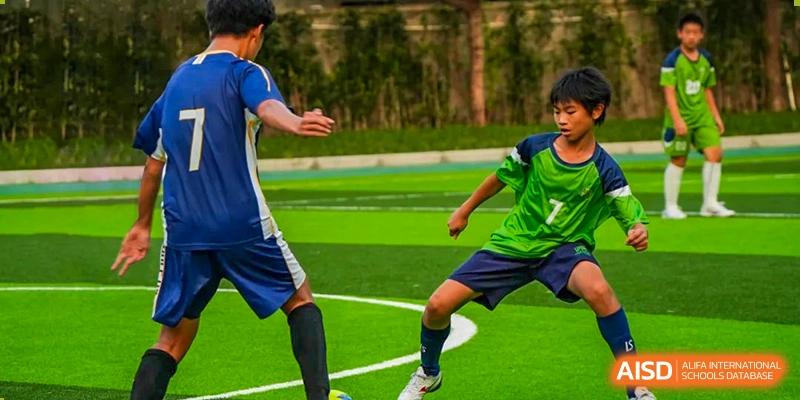 Two male students from YK Pao School playing soccer on a turf field.