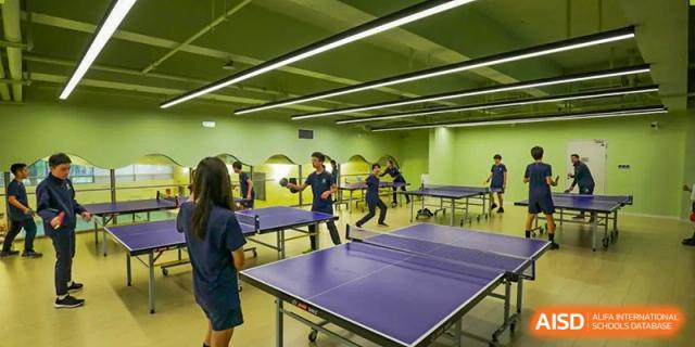 Students from YK Pao School playing table tennis in a recreational area.