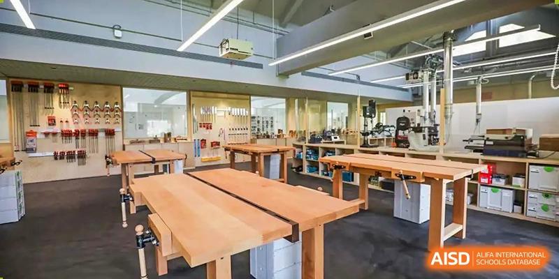 A large, open library or study area at YK Pao School with long wooden tables and various seating options.