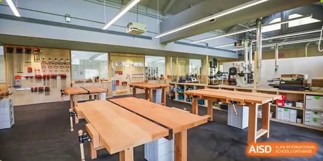 A large, open library or study area at YK Pao School with long wooden tables and various seating options.