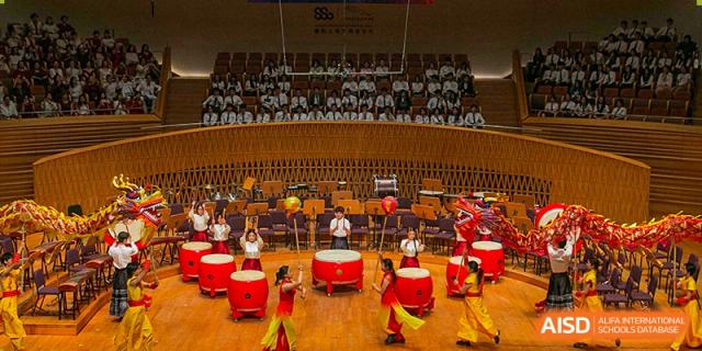 Students from YK Pao School performing a traditional dragon dance with drums and cymbals.