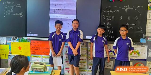 A group of students smiles at the camera as they stand in a classroom. Guangzhou International Primary/Middle School Huangpu