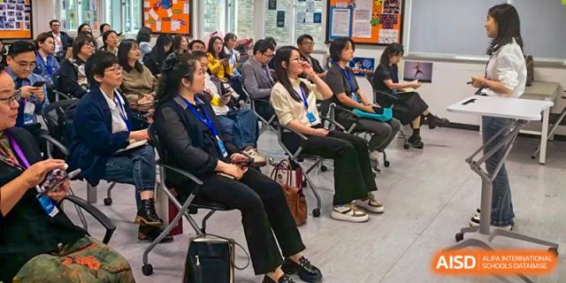 A crowd of people sits in chairs during a presentation. Guangzhou International Primary/Middle School Huangpu