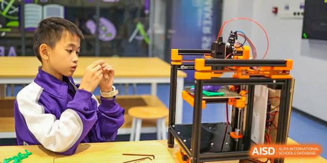 A 3D printer sits on a desk in a classroom. Guangzhou International Primary/Middle School Huangpu