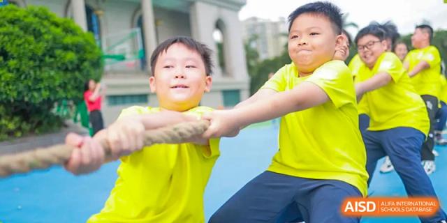 Two boys pull on a rope during a game of tug of war. Guangzhou International Primary/Middle School Huangpu