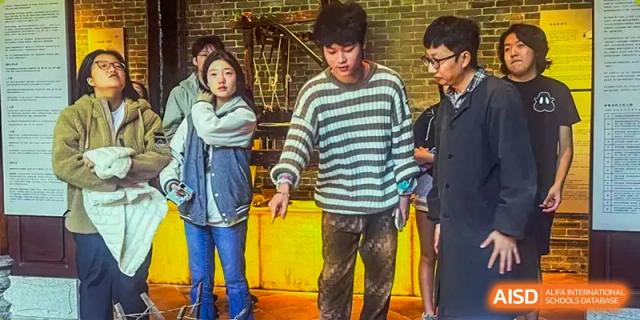 A group of older students from Zhuhai Qiao International School standing together in a casual setting during a school trip or event.